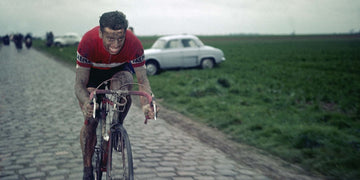 Rik Van Looy in full flight cycling on the cobbled roads of northern europe.